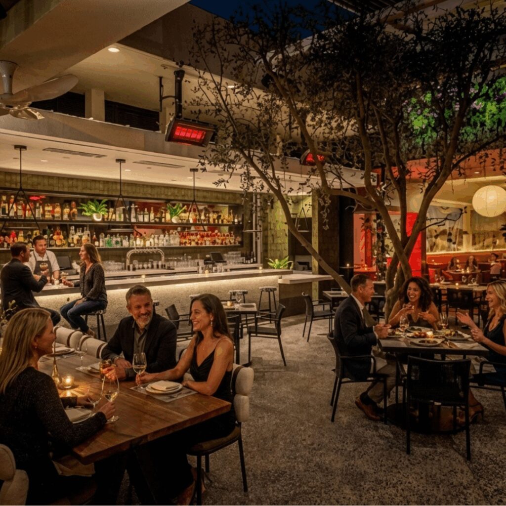 Outdoor restaurant bar with gas patio heaters and guests dining at night